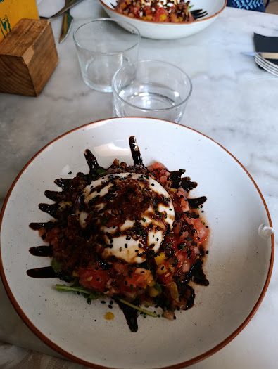 Plato de burrata con tomate servido en la mesa